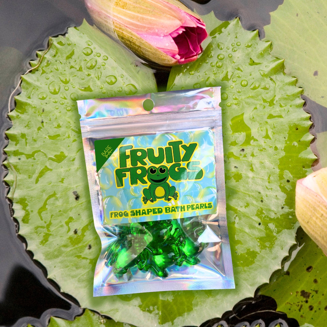 Packaged green frog-shaped bath pearls with 'Fruity Frogs' branding on a leafy background.